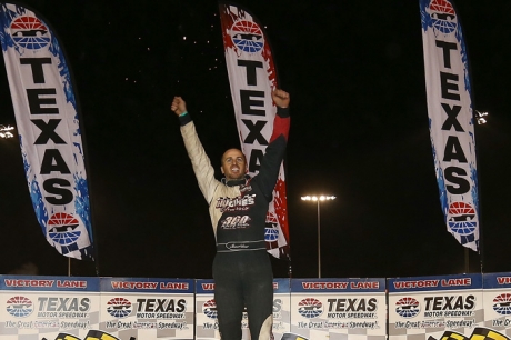 Shane Hebert climbs atop his car in victory lane. (Getty Images)